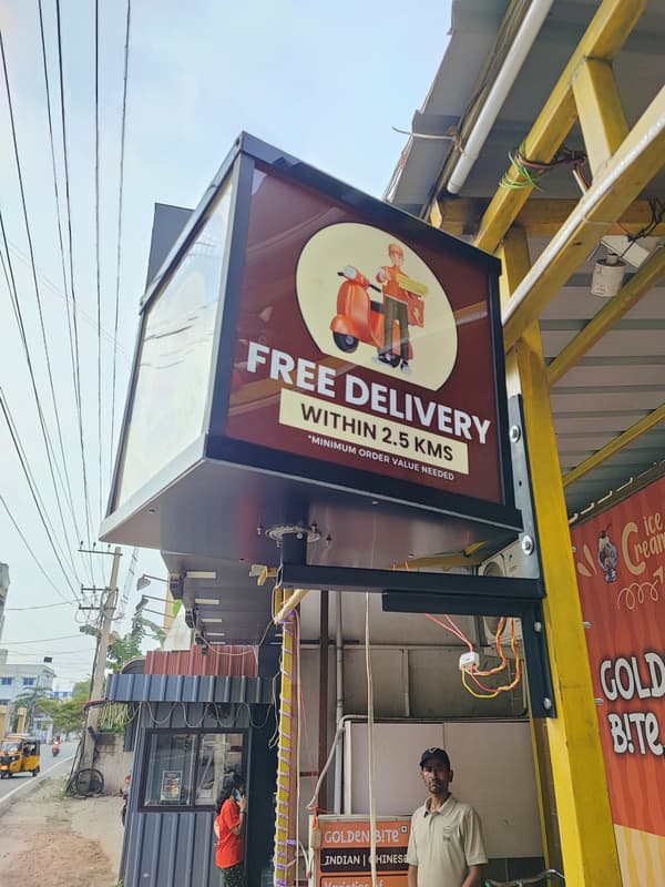 Golden Bite Free Delivery rotary signboard outside the shop