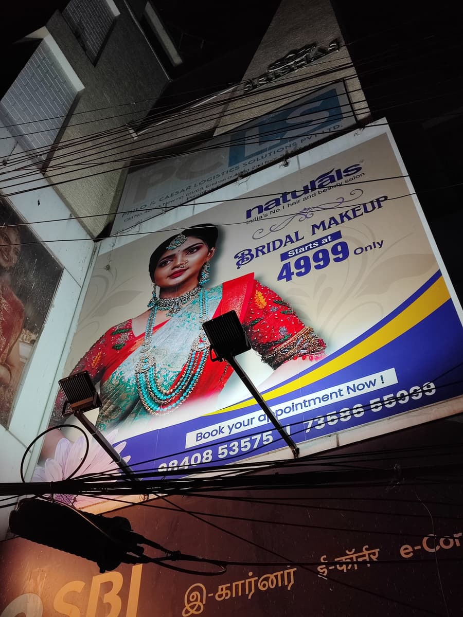 Naturals Bridal Makeup outdoor flex hoarding lit by spotlights