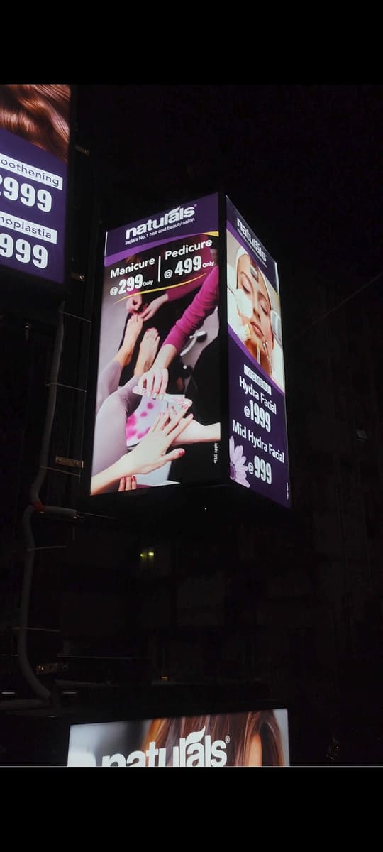 Naturals salon manicure and pedicure rotary standee at night