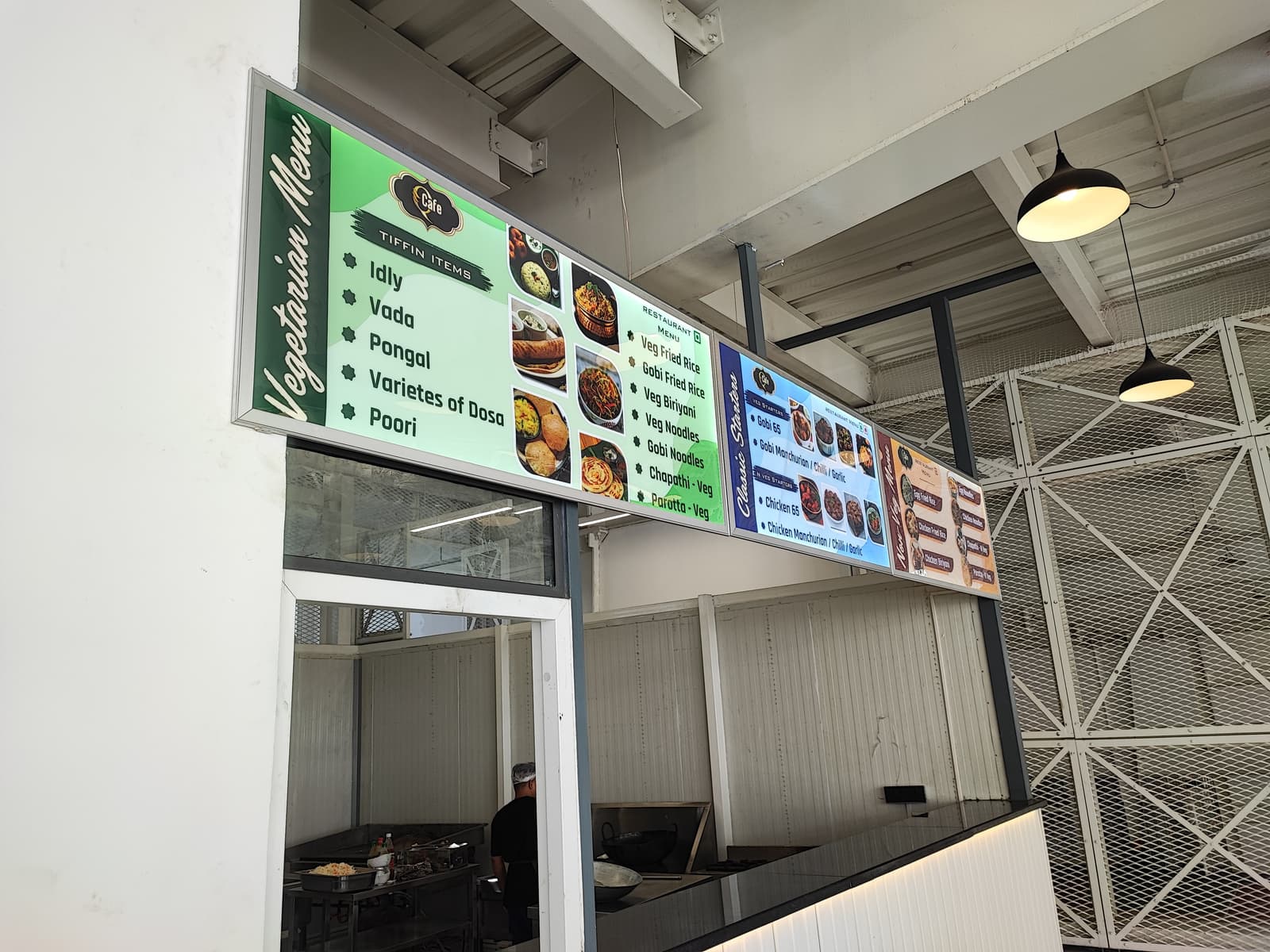 Vegetarian tiffin items menu signage above the kitchen counter